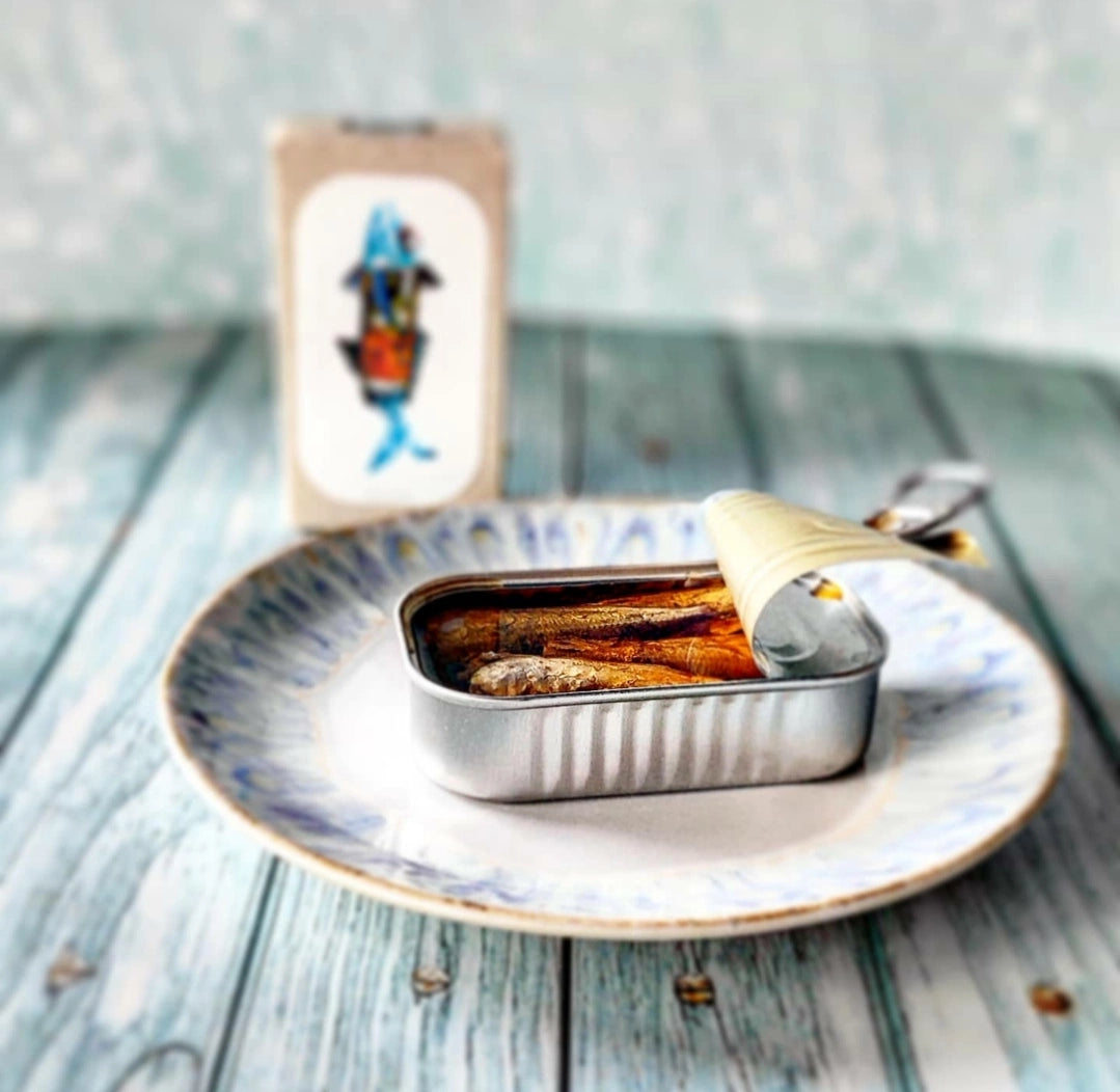 Jose Gourmet Stickleback in Pickled Sauce on a plate with a decorative card in the background