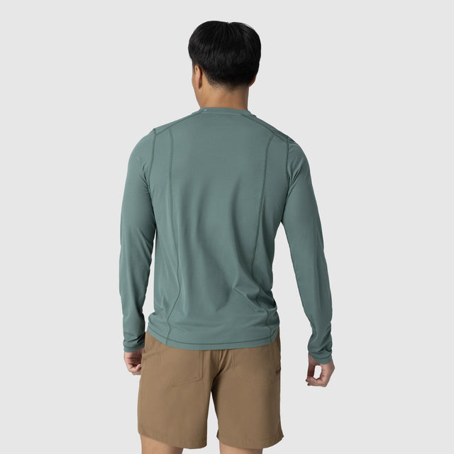 Person wearing an Outdoor Research Men's Echo Long Sleeve Tee in Malachite on a light gray background