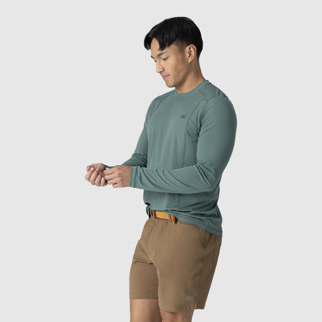 Man wearing an Outdoor Research Men's Echo Long Sleeve Tee in Malachite on a white background