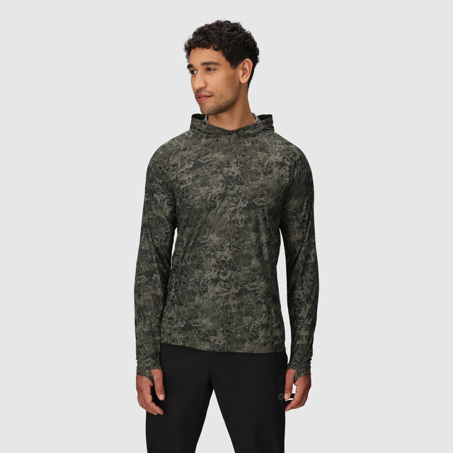 Man wearing a Outdoor Research Men's Echo Hoodie in Ranger Green Granite Print on a light gray background