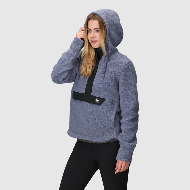Woman wearing an Outdoor Research Women's Grayland Fleece Pullover Hoodie on a light gray background