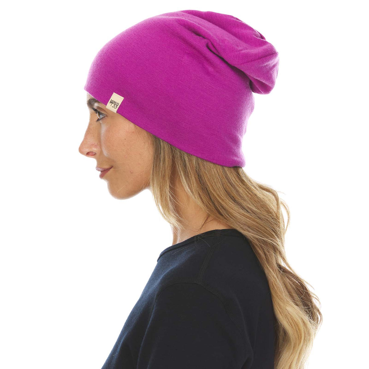 Minus33 Ridge Cuff Merino Wool Beanie in Radiant Violet being worn by a woman on a neutral background.