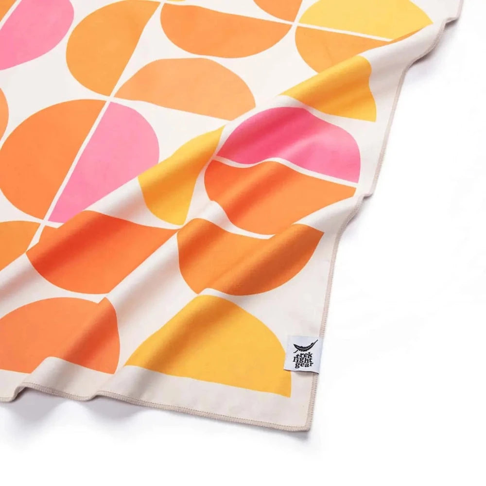 Trek Light Half Moon Wander towel is made from recycled plastic bottles and features a colorful half moon pattern.