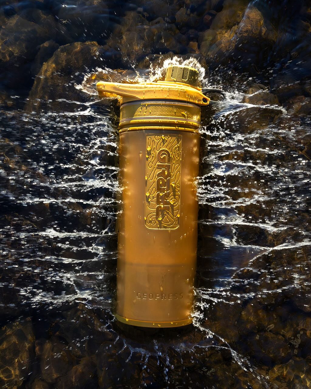 Grayl GeoPress Water Purifier Bottle on a watery background in Coyote Brown.