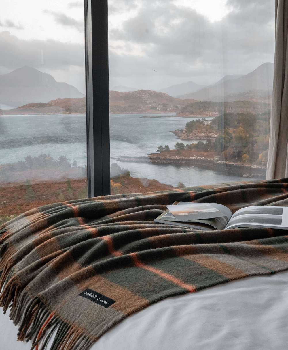 Sackcloth & Ashes Folk Olive camping blanket inside with a view of nature.