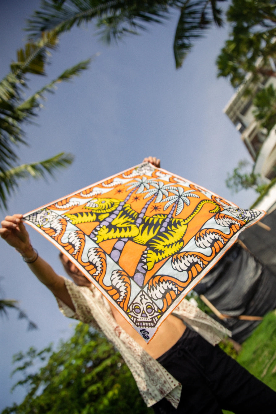 Bandits Bandana Trapped In bandana being held in front of a palm tree.