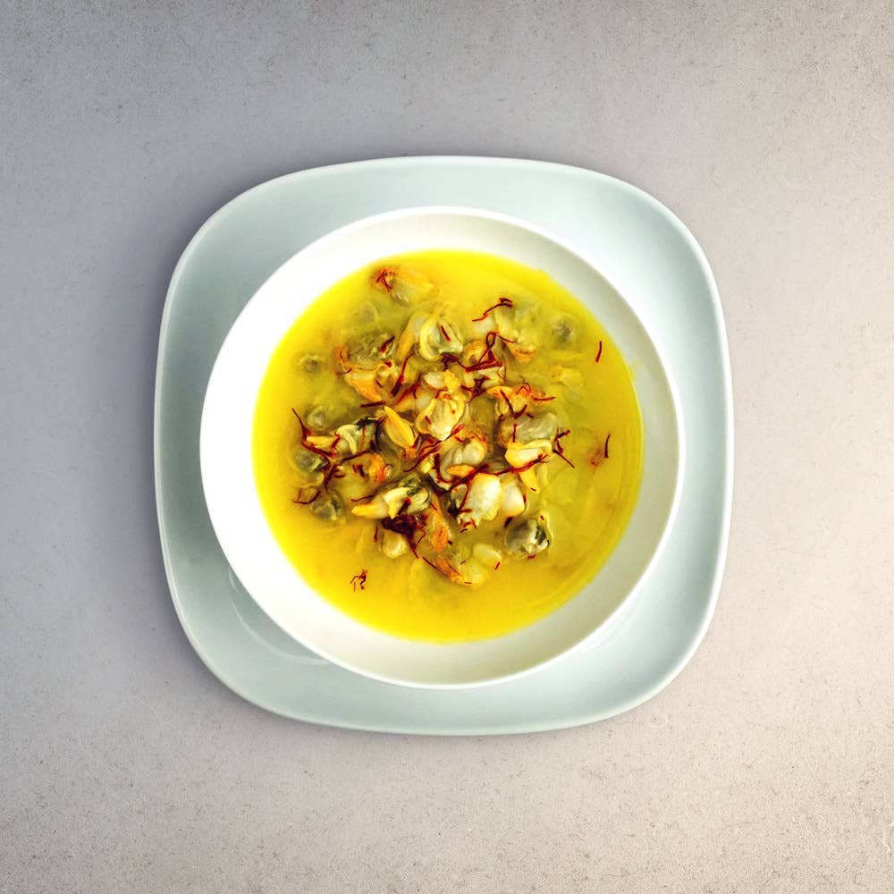 La Narval Galician Cockles in Brine with garnish in a white bowl on a light gray background