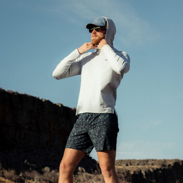 Outdoor Research men's Echo Hoodie sun hoodie in Pebble worn by a man hiker.