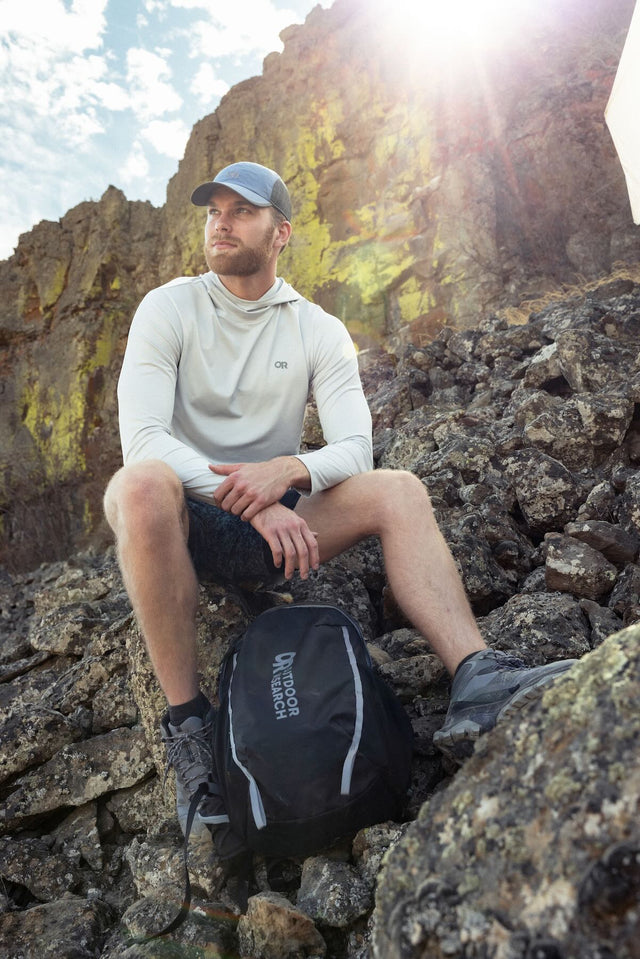 Outdoor Research men's Echo Hoodie sun hoodie in Pebble worn by a man hiker.