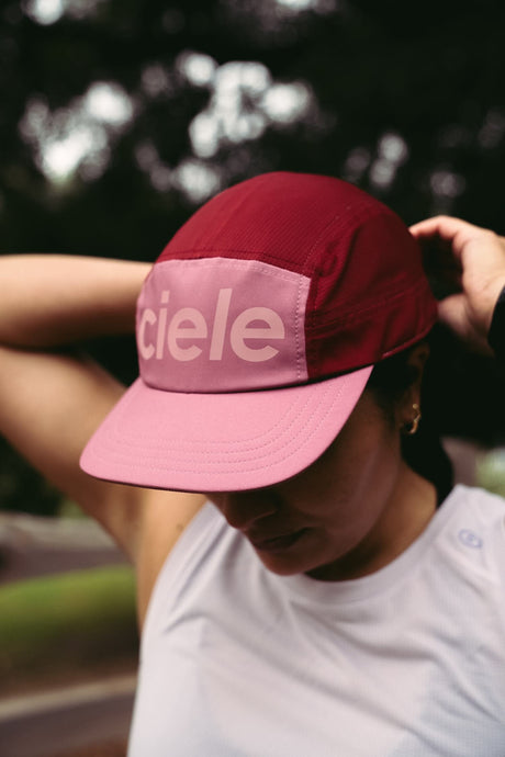 Ciele Athletics GOCap Comp Century in Deco Rose worn by a runner outdoors.