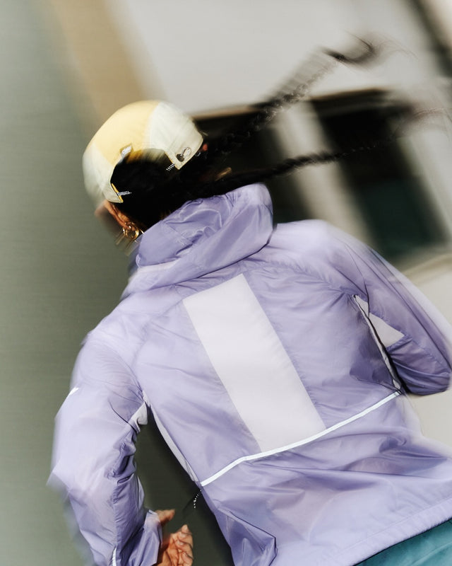 Ciele Athletics W VNTJacket women's running jacket in Light Grape worn by a woman runner outdoors.