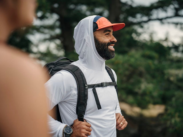 Outdoor Research men's Echo Hoodie sun hoodie in Pebble worn by a man hiker.
