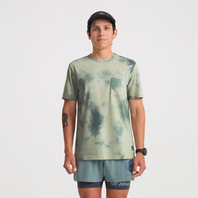 Man wearing a Roark Mathis Active Tie Dye Pocket Short Sleeve Tee in Seafoam and shorts on a white background