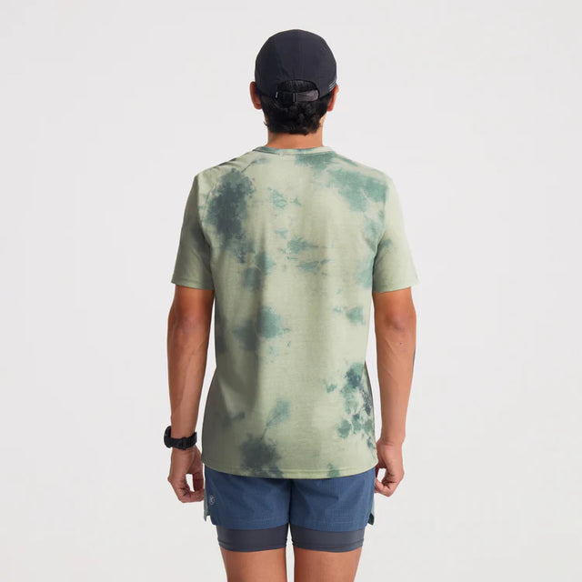 Person wearing a Roark Mathis Active Tie Dye Pocket Short Sleeve Tee in Seafoam and blue shorts on a white background