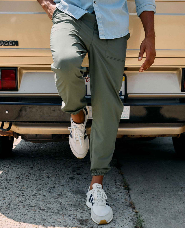 Toad&Co Men's Boundless Jogger in Beetle worn by a runner outdoors.