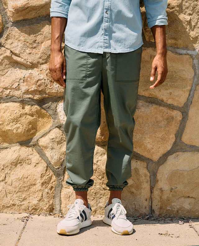 Toad&Co Men's Boundless Jogger in Beetle worn by a runner outdoors.