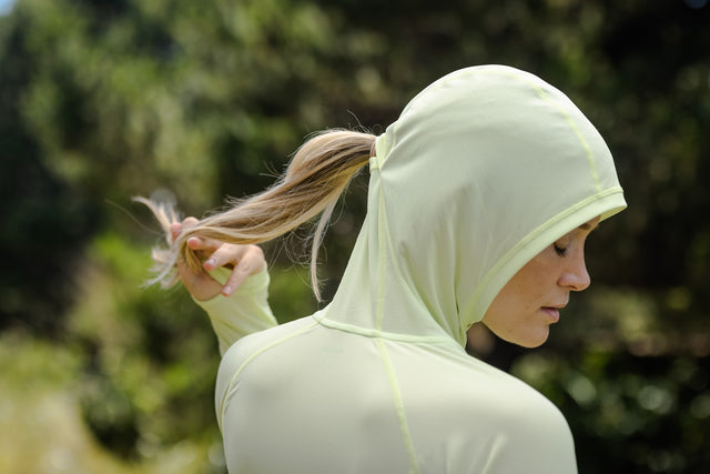 Outdoor Research Women's Echo Hoodie sun hoodie in Cool Matcha worn by a woman hiker.
