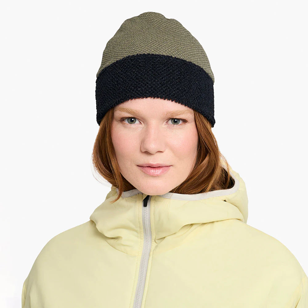 Person wearing a ciele UHBeanie fleece running beanie in Canvas and light-colored hoodie on a white background