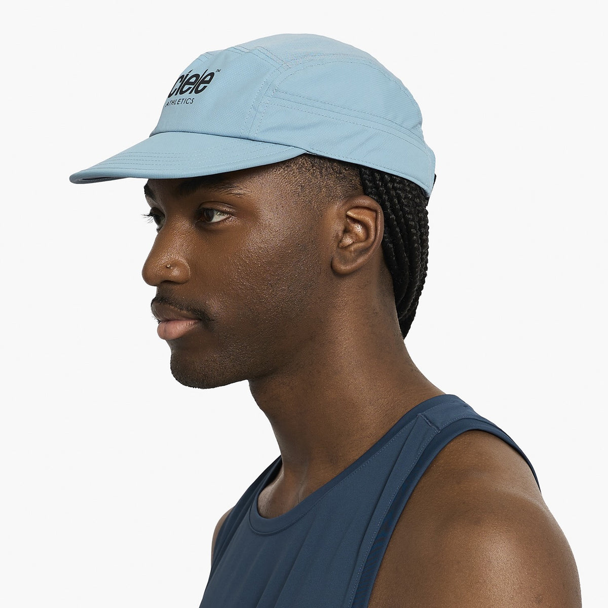 Man wearing a Ciele Athletics GOCap Classic - Athletics Chambray blue running cap with a brand logo on a white background