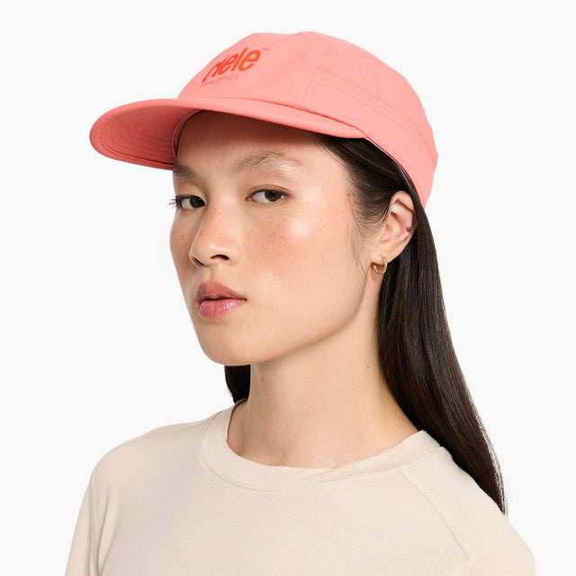 Person wearing a Ciele Athletics GOCap Classic - Athletics Blossom Coral running cap with 'hello' text on a white background