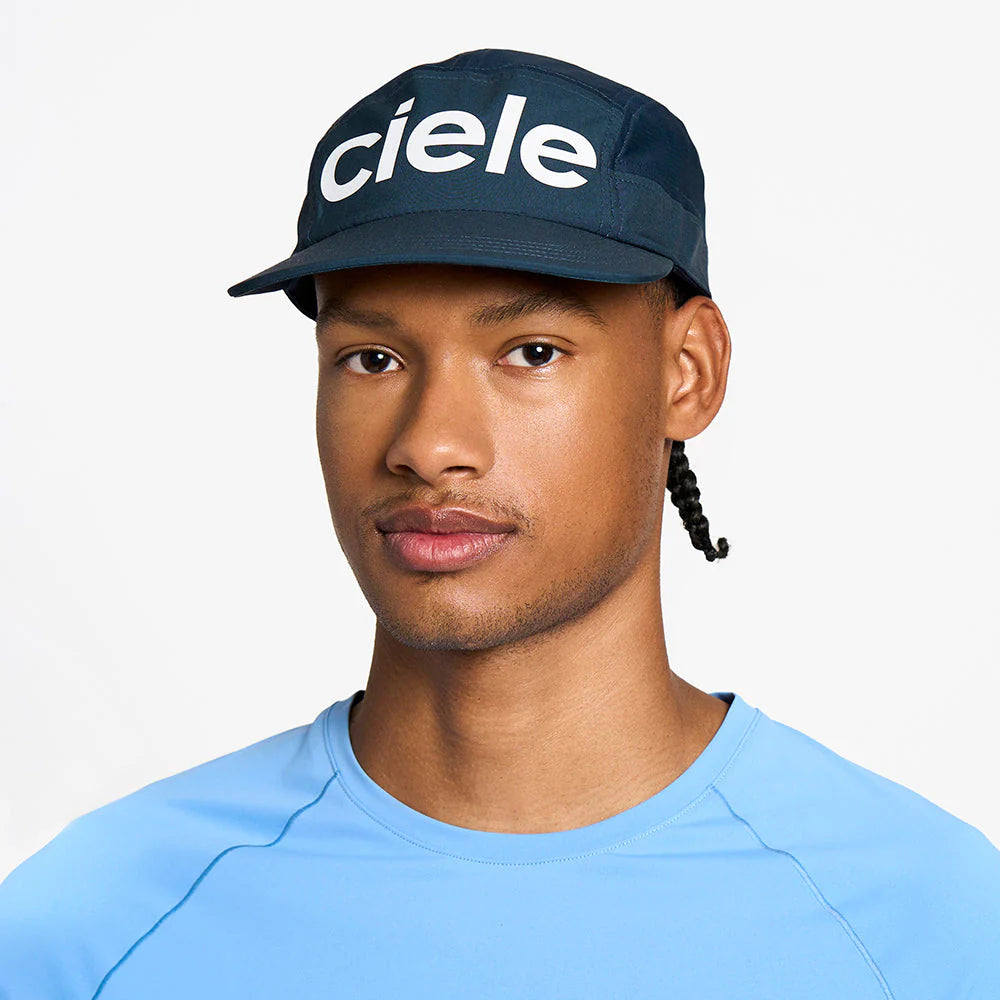 Person wearing a navy ciele athletics GOCap Comp - Century in Deep Space with 'ciele' logo on a white background
