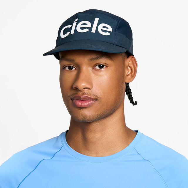 Person wearing a navy ciele athletics GOCap Comp - Century in Deep Space with 'ciele' logo on a white background