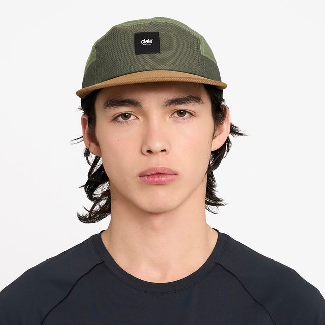Person wearing a ciele athletics GOCap EQ - Frame S in Olive running hat with a visible brand logo on a white background