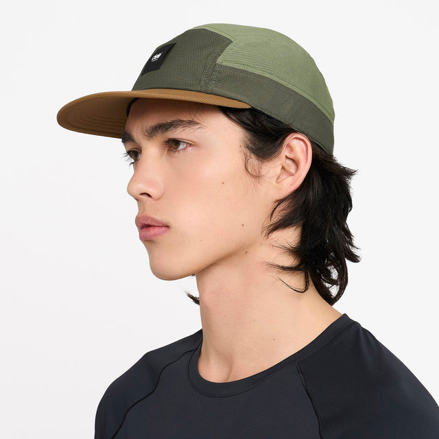 Person wearing a ciele athletics GOCap EQ - Frame S in Olive running hat on a white background