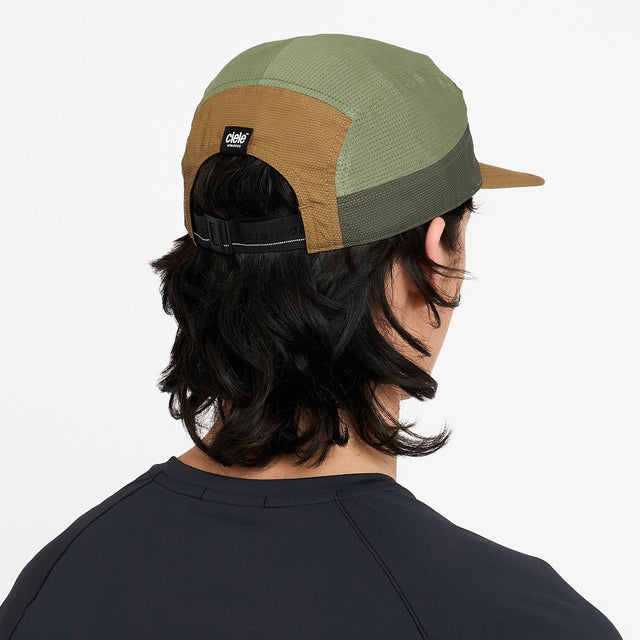 Person wearing a ciele athletics GOCap EQ - Frame S in Olive running hat with a visible brand logo on a white background
