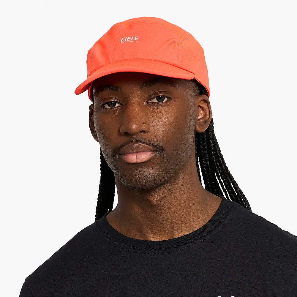 Person wearing an orange GOCap SC Field - Capital RC running hat in Infrared with 'Ciele' branding on a white background