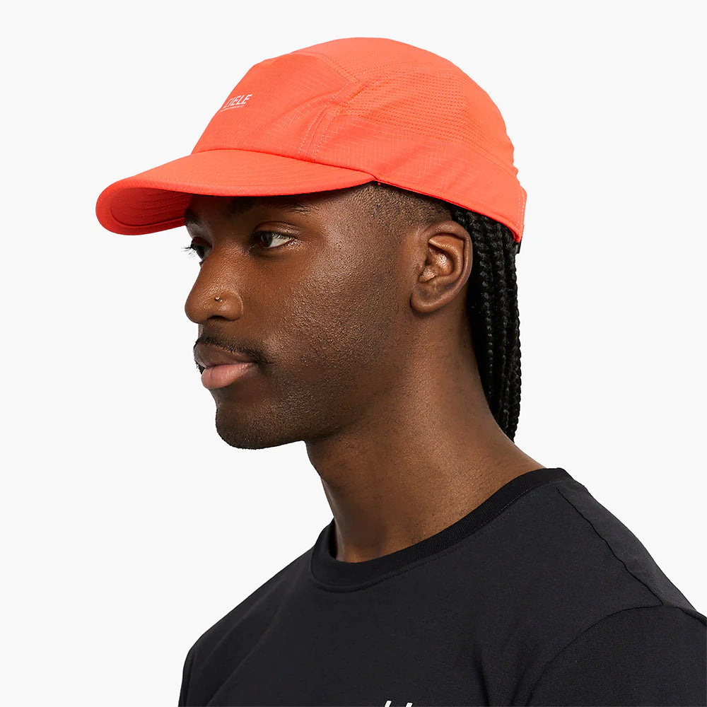 Person wearing an orange GOCap SC Field - Capital RC running hat in Infrared and black shirt on a white background