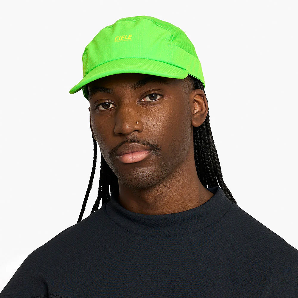 Person wearing a ciele athletics GOCap SC Field - Capital RC running hat in Acid Green on a plain background