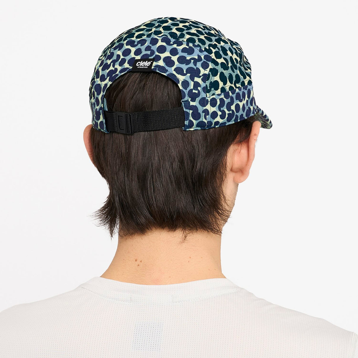 Person wearing a Ciele Athetlics GOCap SC Field - All Over Dotra running hat in Deep Space on a white background
