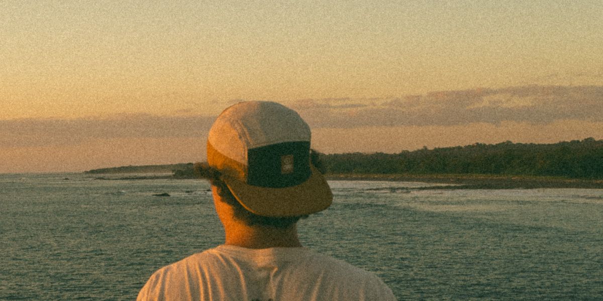 Runner wearing a Ciele hat on a beach.