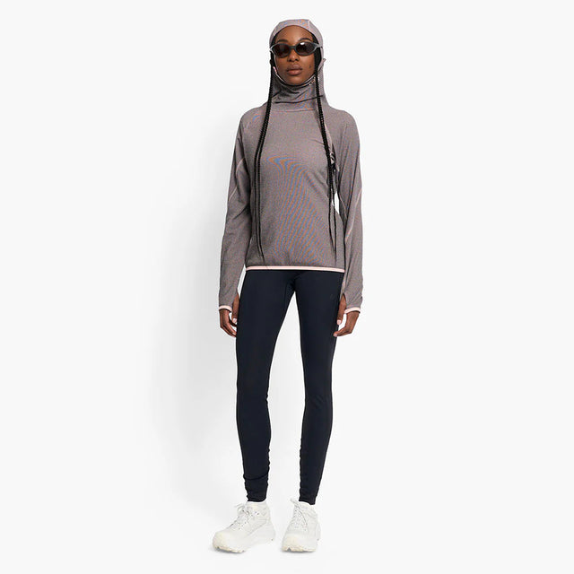 Person wearing a Ciele Athletics Women's IBTHoody - Fleece Running Hoodie in Peachskin and black leggings on a white background