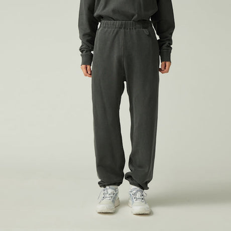 Person wearing Snow Peak Garment Dyed Pants in Charcoal and a matching top on a light gray background