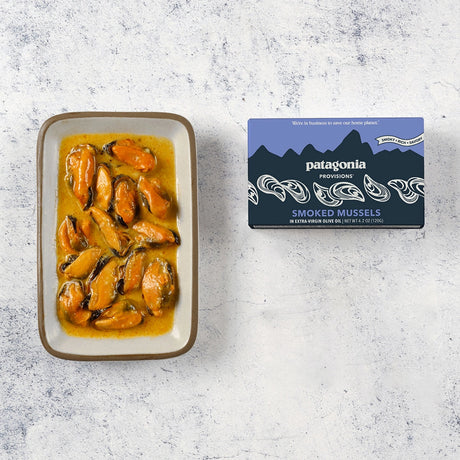 Platter of smoked mussels next to Patagonia Provisions packaging on a textured surface