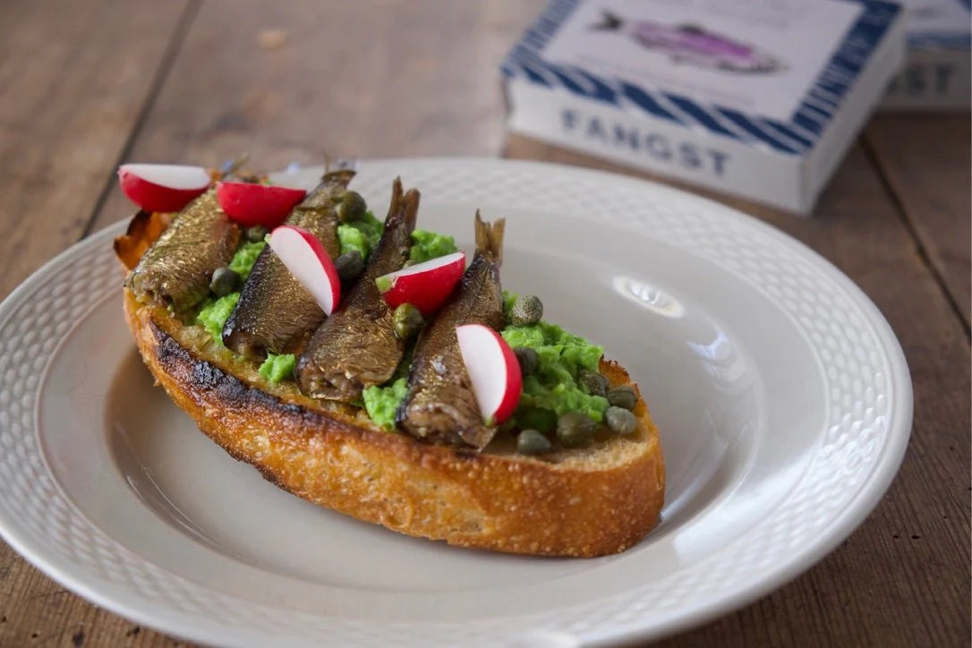 Plated dish with Fangst Nordic Smoked Sardine with Heather & Chamomile on a wooden table