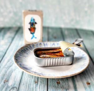 Jose Gourmet Stickleback in Pickled Sauce on a plate with a decorative card in the background