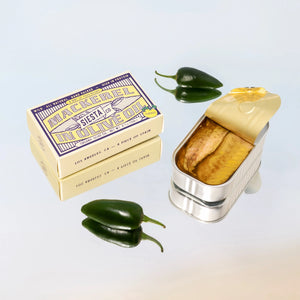 Mackerel in Yuzu Kosho can with packaging and jalapeño peppers on a gradient background