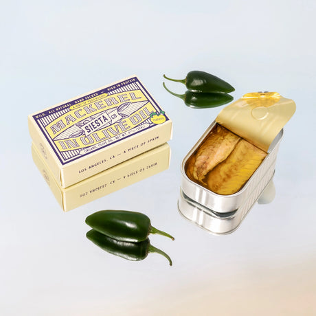 Mackerel in Yuzu Kosho can with packaging and jalapeño peppers on a gradient background