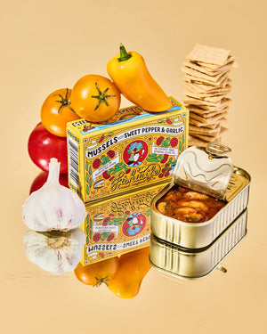 Vintage-style packaging of 'Fishwife Mussels in Sweet Pepper & Garlic' with ingredients on a beige background