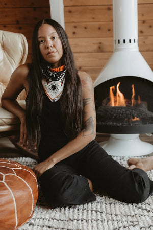 Bandits Bandana Get Lost bandana being worn by a woman in front of a fire.