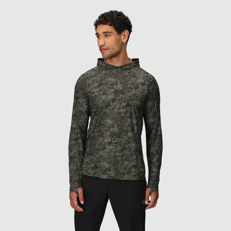 Man wearing a Outdoor Research Men's Echo Hoodie in Ranger Green Granite Print on a light gray background