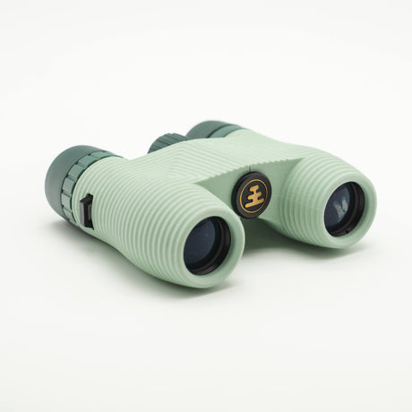 Nocs Standard Issue 8x25 Waterproof Binoculars in glacial blue on a neutral background.