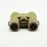 Nocs Provisions Field Issue 10X Waterproof Binoculars in Ponderosa Green on a neutral background showing the eye pieces.