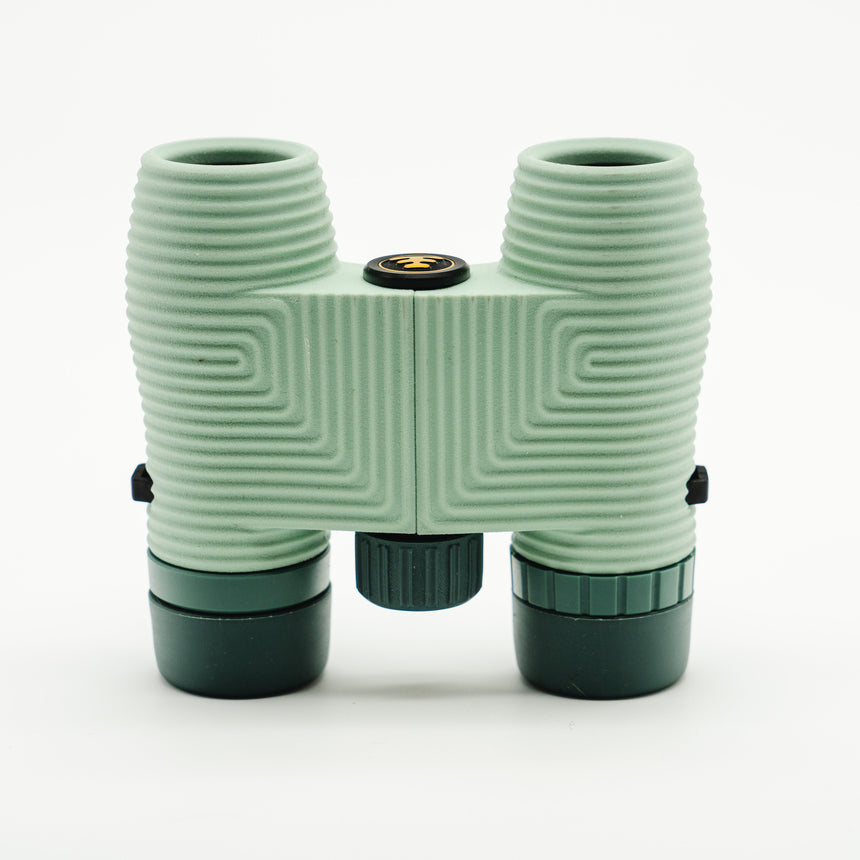 Nocs Standard Issue 8x25 Waterproof Binoculars in glacial blue on a neutral background from above.