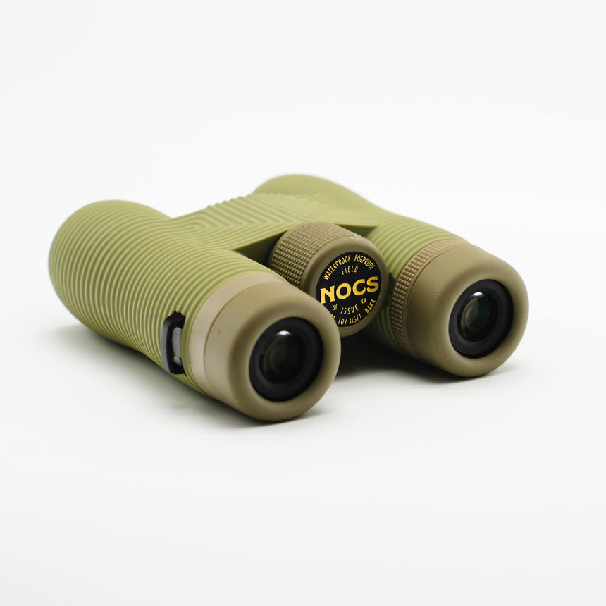 Nocs Provisions Field Issue 10X Waterproof Binoculars in Ponderosa Green on a neutral background at an angle.