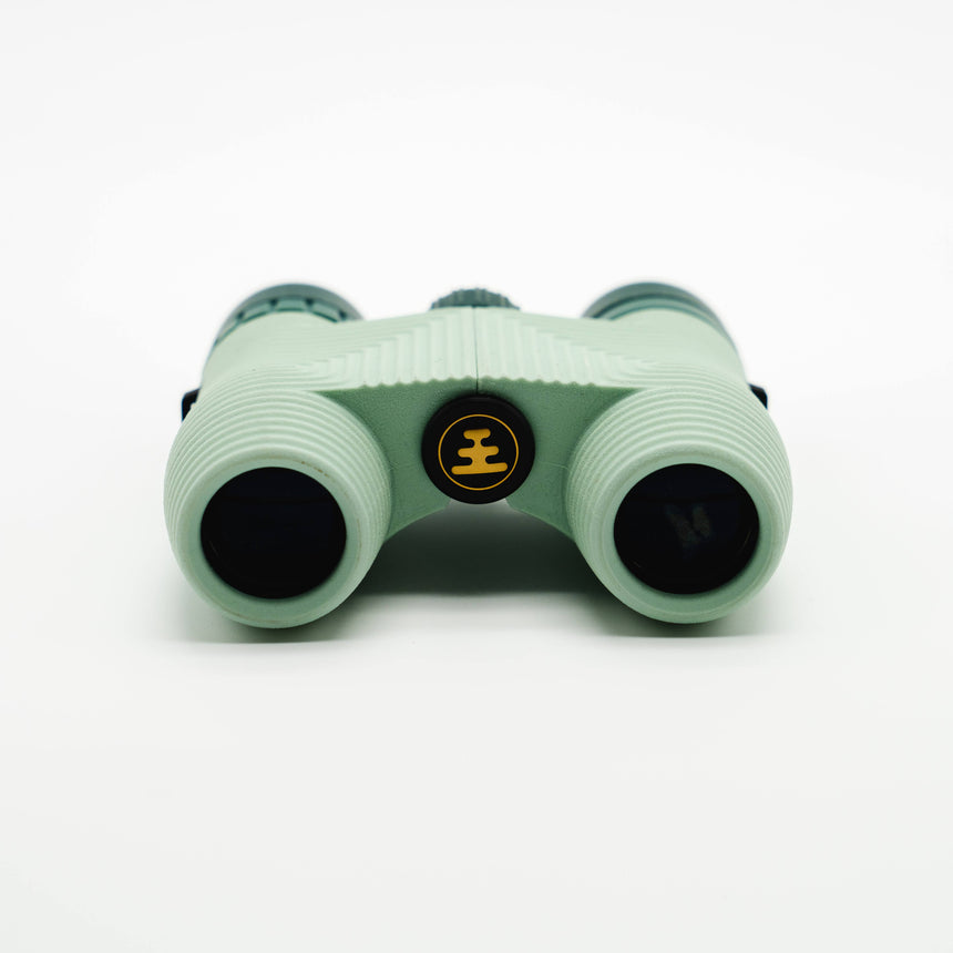 Nocs Standard Issue 8x25 Waterproof Binoculars in glacial blue on a neutral background showing the lenses.