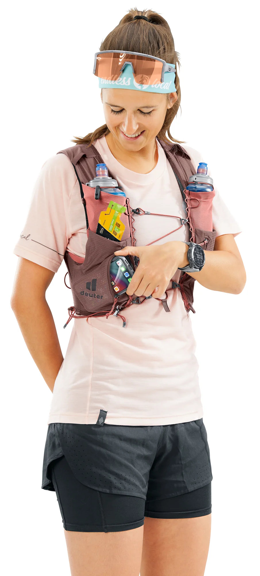 deuter Traick 5 SL running hydration vest in Raisin-Caspia worn by a woman on a neutral background.